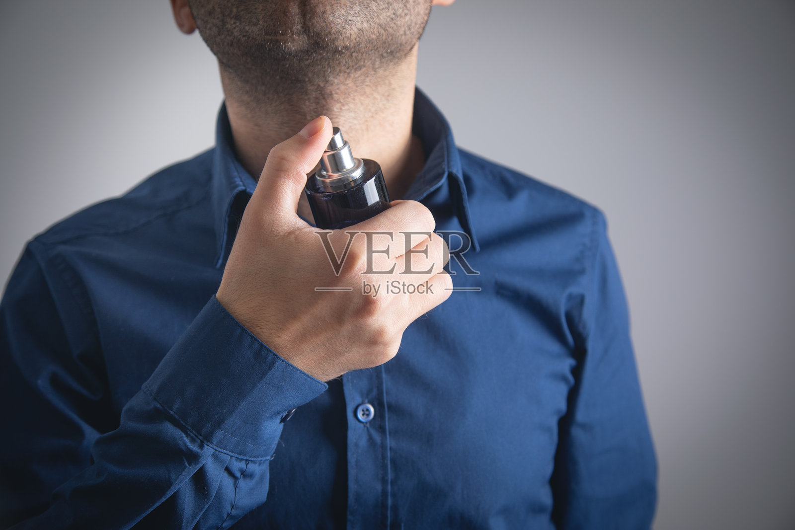 白人男性手持香水瓶。美容。时尚。照片摄影图片