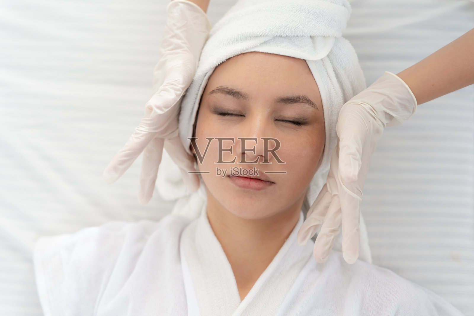 美丽的女性正在接受面部按摩和治疗，以恢复毛孔、减少皱纹、提升紧致、变得更美，享受放松，拥有婴儿般的肌肤。休闲、娱乐、皮肤科。照片摄影图片