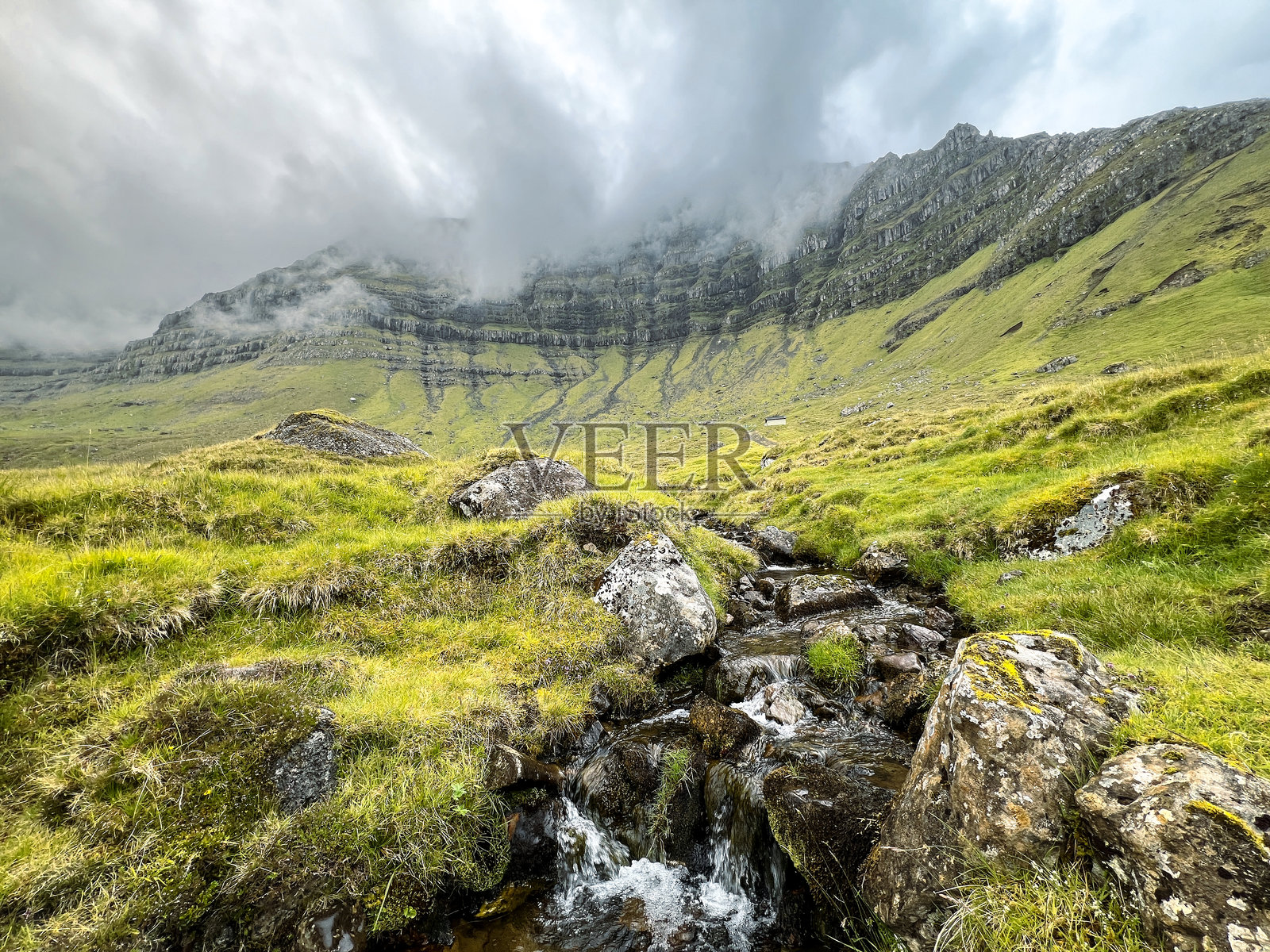 瀑布池被壮丽的山脉和阴郁的天空环绕照片摄影图片