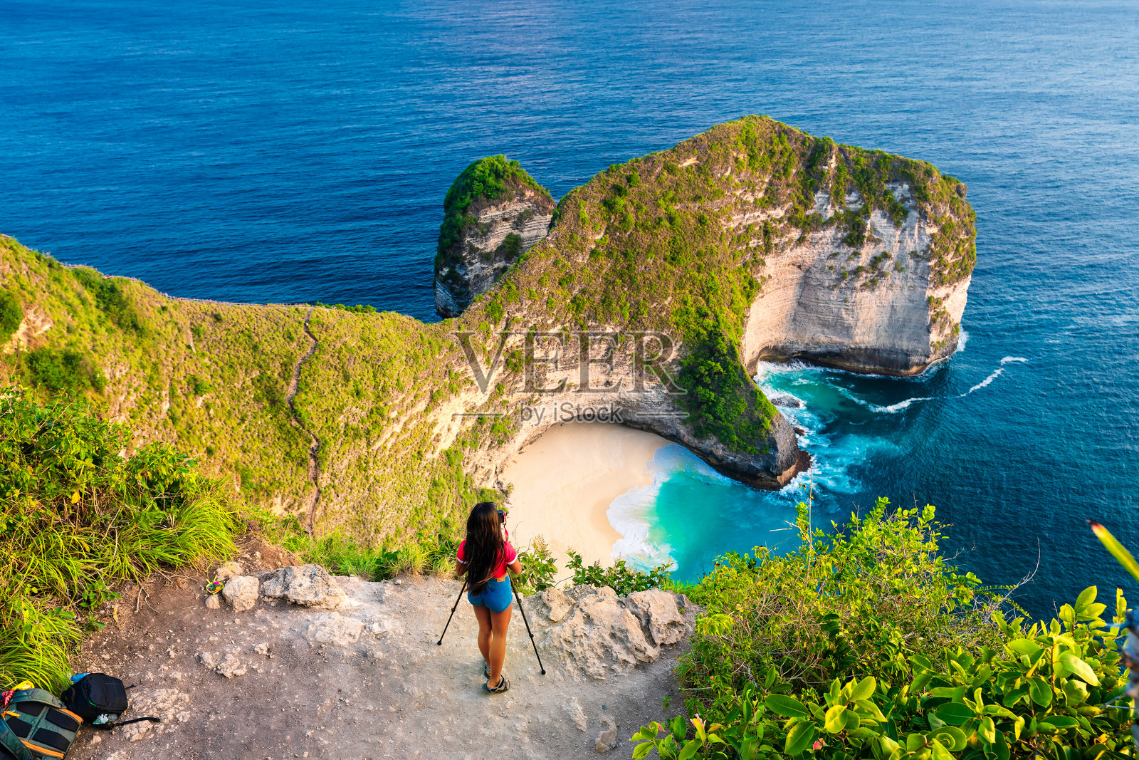 旅行者探索最美丽和著名的旅游胜地——巴厘岛的克林金海滩，那里有令人难以置信的山岩和清澈的海洋。照片摄影图片