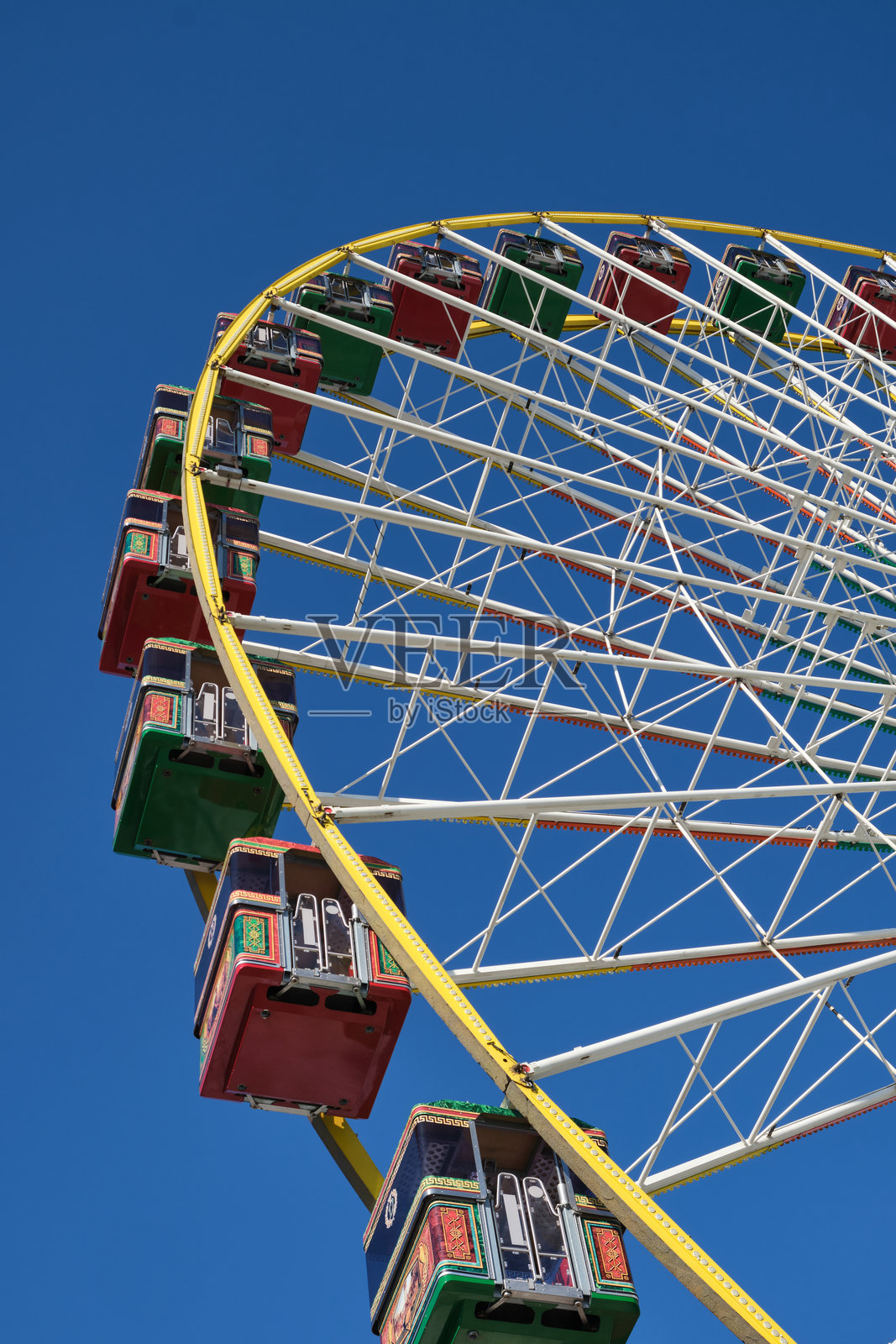 游乐场前的摩天轮，五彩缤纷的观光舱在蓝天映衬下显得格外迷人照片摄影图片