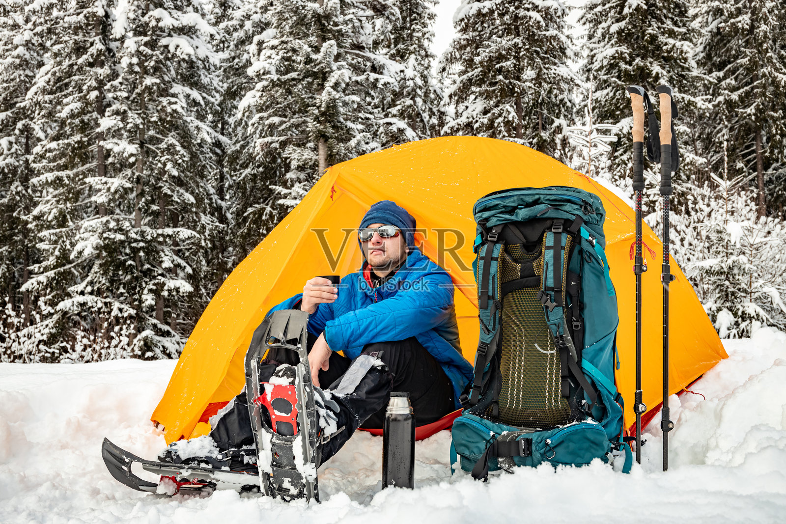 背着背包和帐篷在山中冬季徒步旅行。照片摄影图片