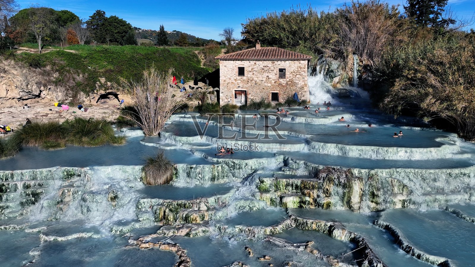 游客在意大利托斯卡纳的萨图尔尼亚温泉水中放松。照片摄影图片