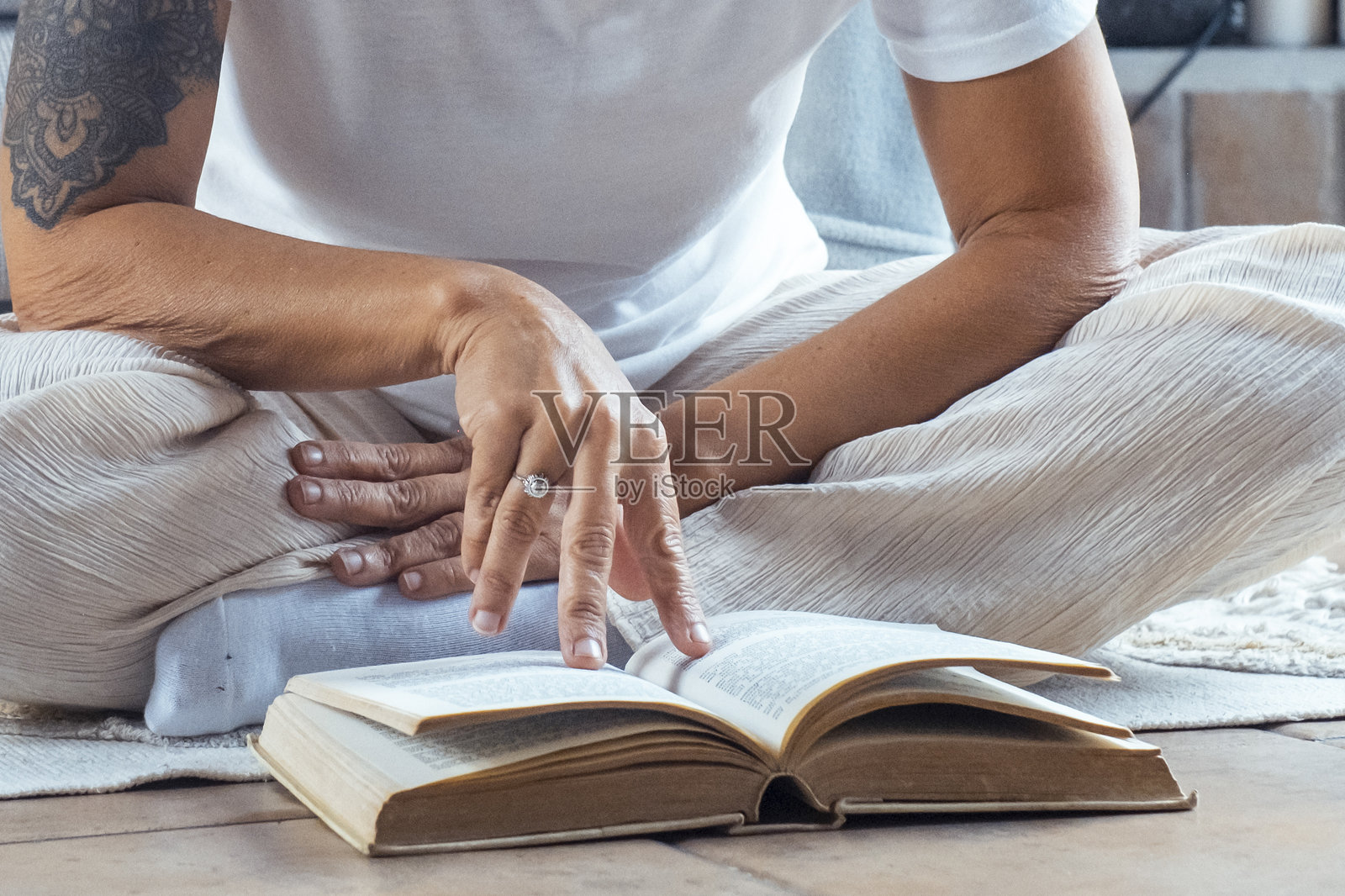 放松的女性坐在室内，享受宁静的下午，戴着眼镜，阅读一本书，周围是温馨宁静的家居环境，享受着宁静的独处时光。照片摄影图片