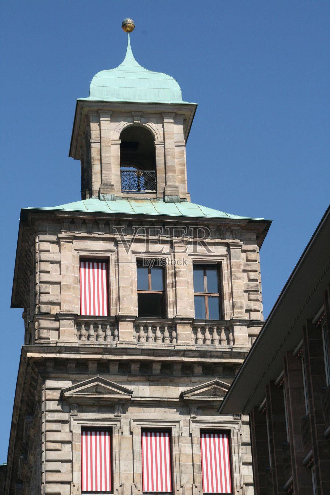 有条纹窗户和绿色圆顶的历史建筑。照片摄影图片