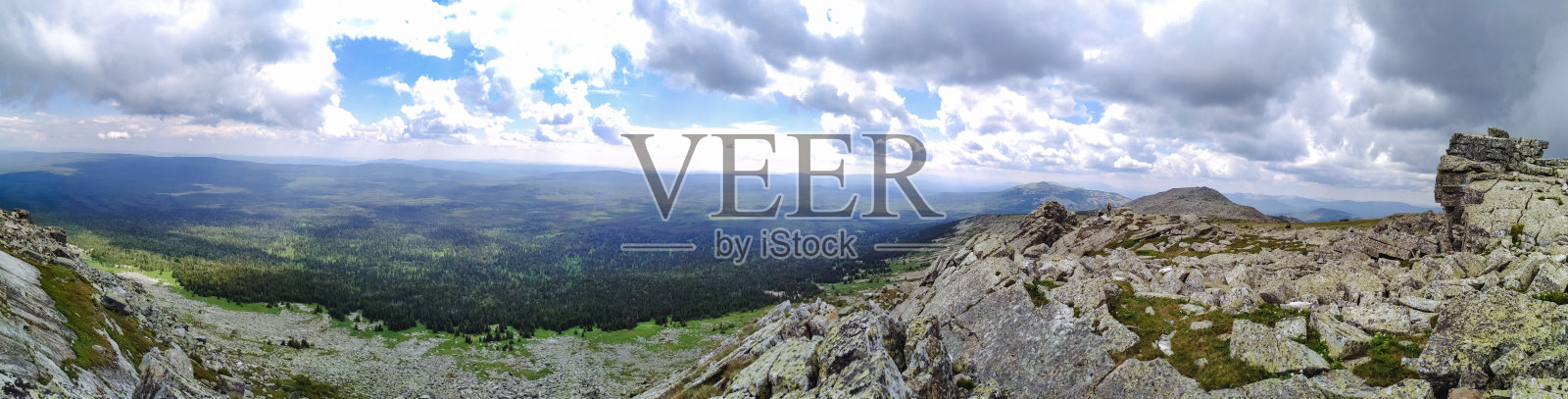 这幅图像模糊地描绘了一幅美丽的山脉风景，背景中有多云的天空，整体营造出一种宁静的氛围，四周环绕着自然。照片摄影图片