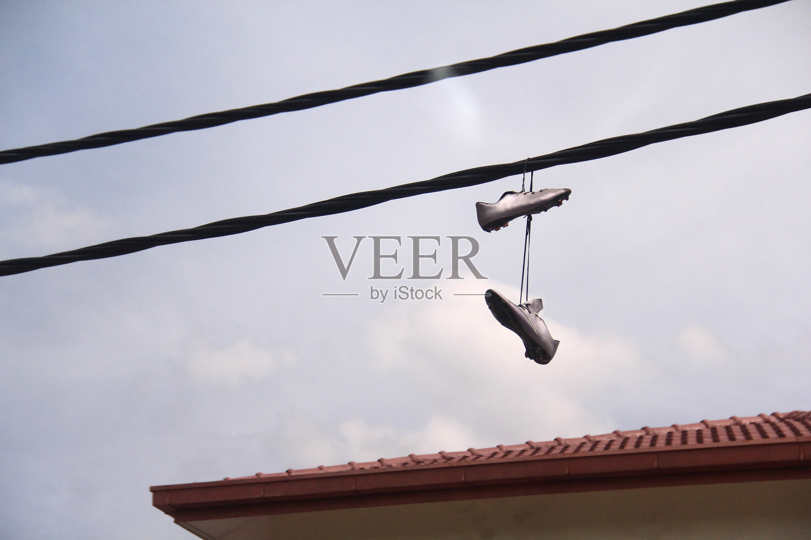 阴云密布的氛围：悬空的鞋子照片摄影图片