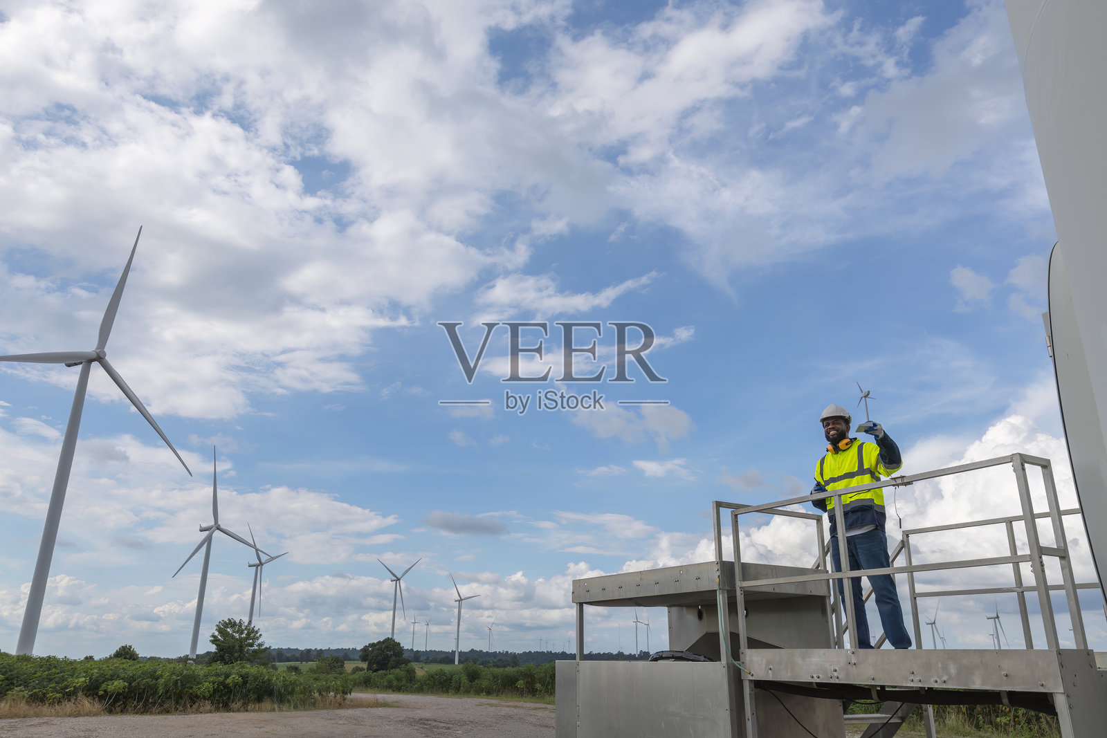 调查团队未来的替代能源。工程师在日落时检查风力涡轮机。风力涡轮机可再生能源技术与可持续性。照片摄影图片