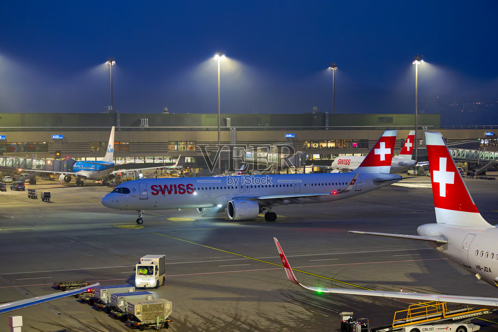 高角度视图的瑞士航空空客A321neo（注册号HB-JPD）在瑞士苏黎世克洛滕机场的冬夜滑行。照片摄影图片