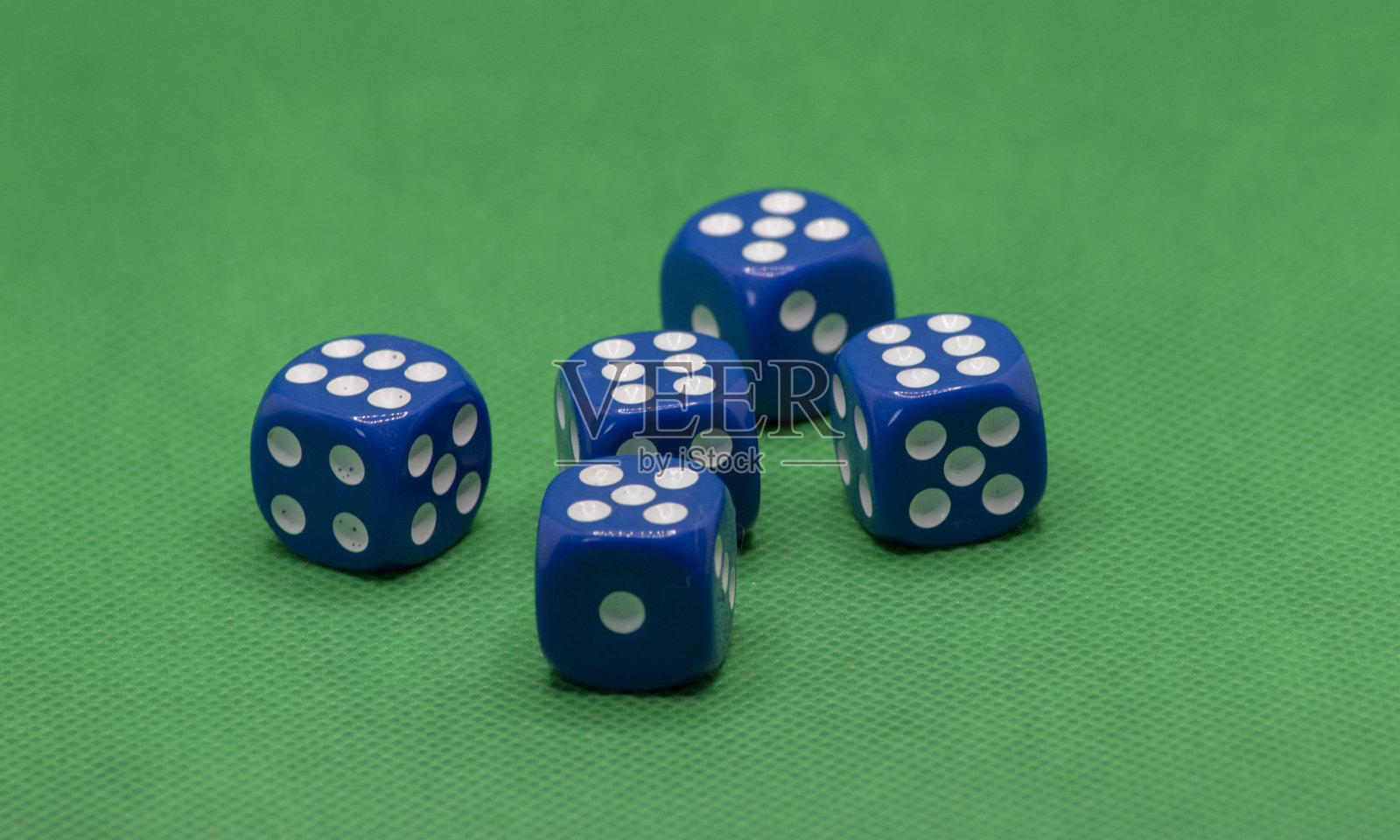蓝色骰子（赌博骰子）与白色点和绿色背景的照片照片摄影图片