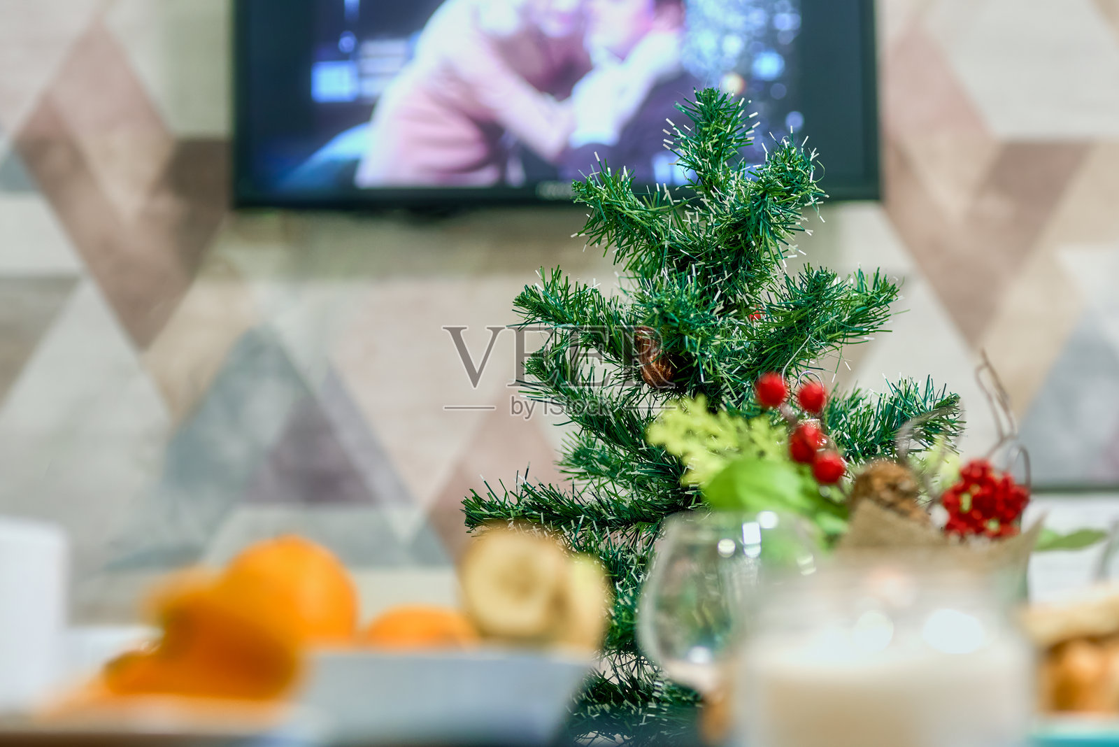 节日新年餐桌上的小型人造圣诞树。照片摄影图片