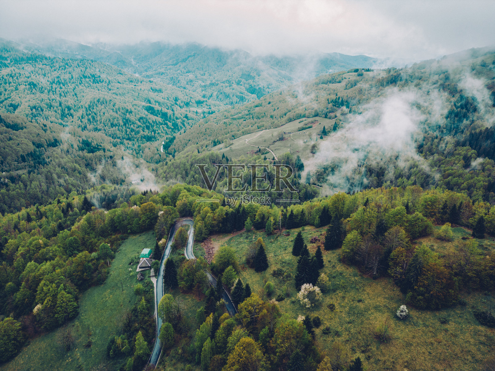 迷雾中的山丘和蜿蜒的乡村道路照片摄影图片