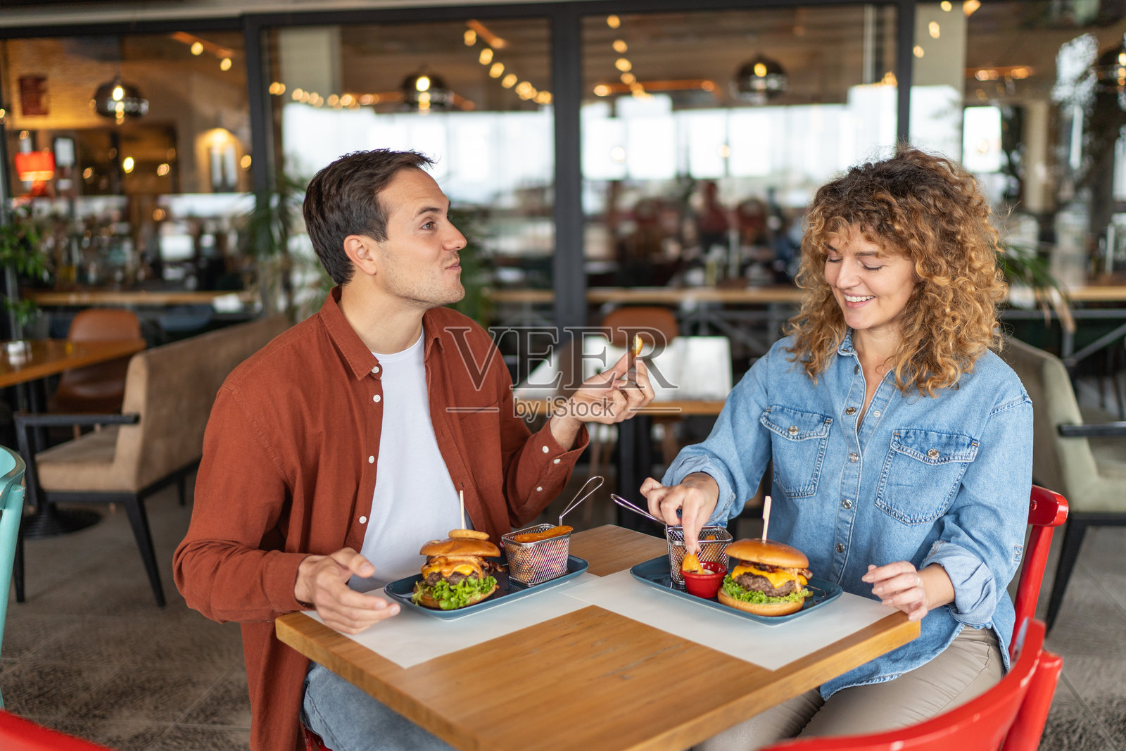 年轻情侣欢笑着享受汉堡照片摄影图片