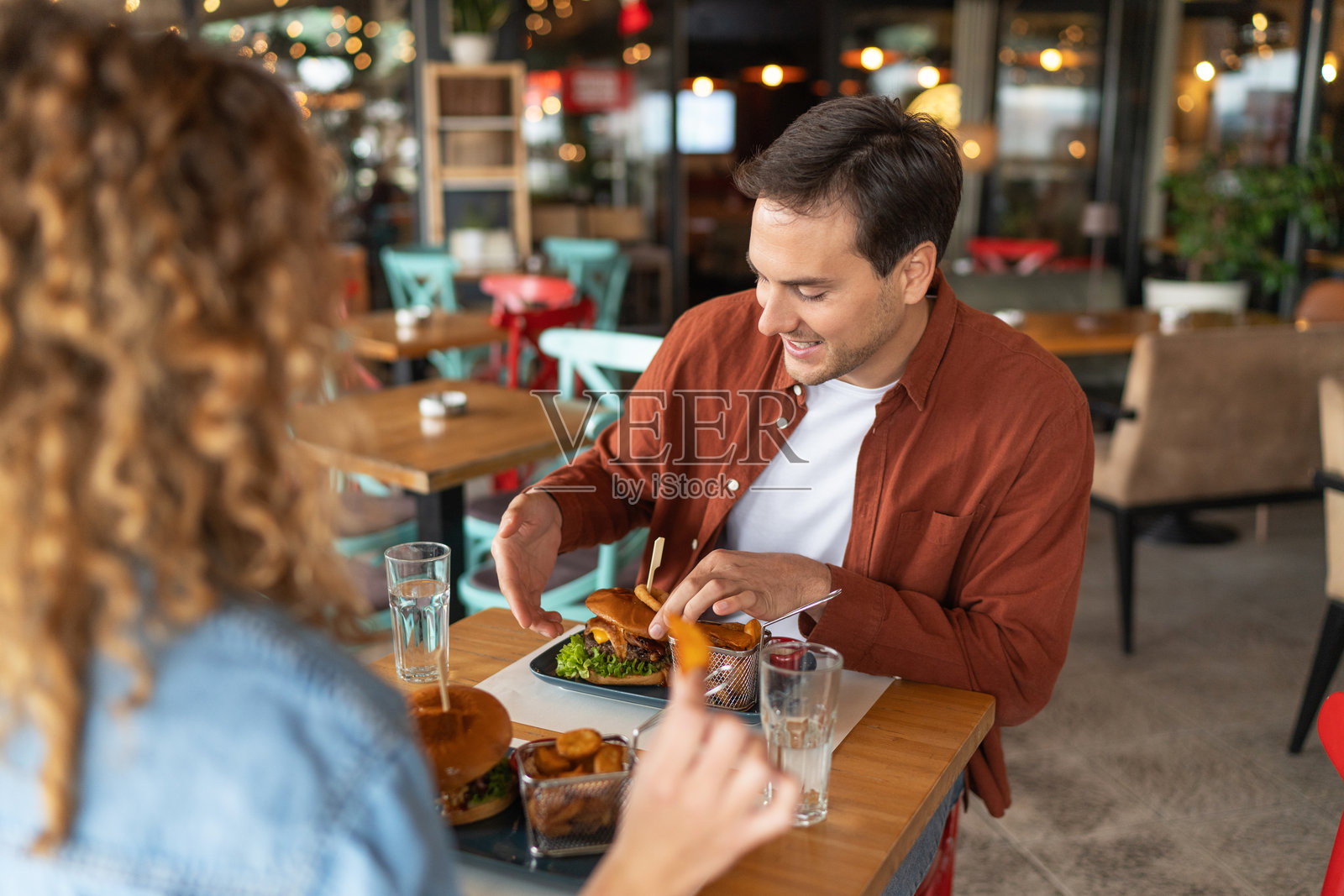 年轻情侣欢笑着享受汉堡照片摄影图片