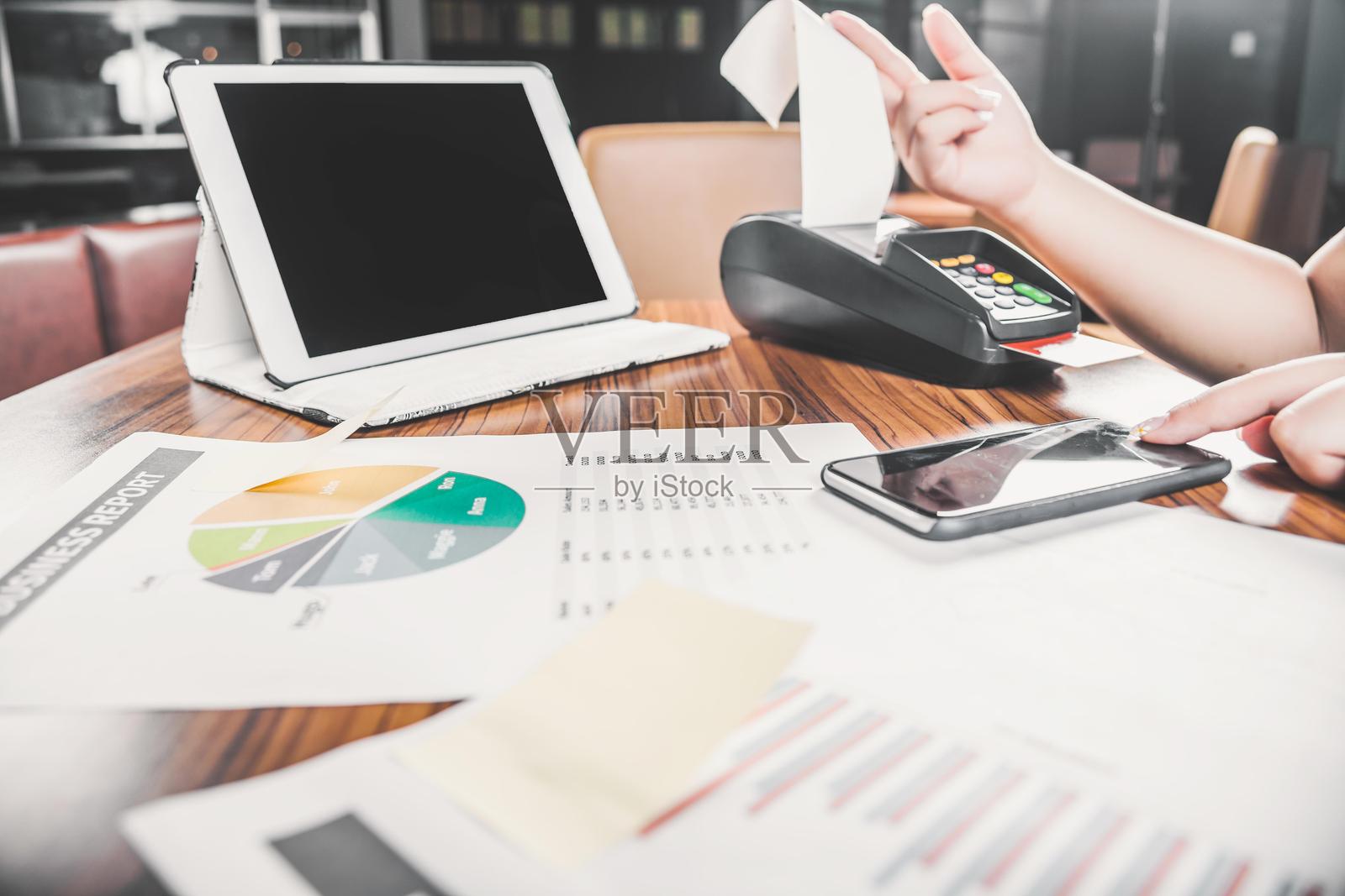 使用平板电脑和智能手机的信用卡机进行商业收据支付照片摄影图片