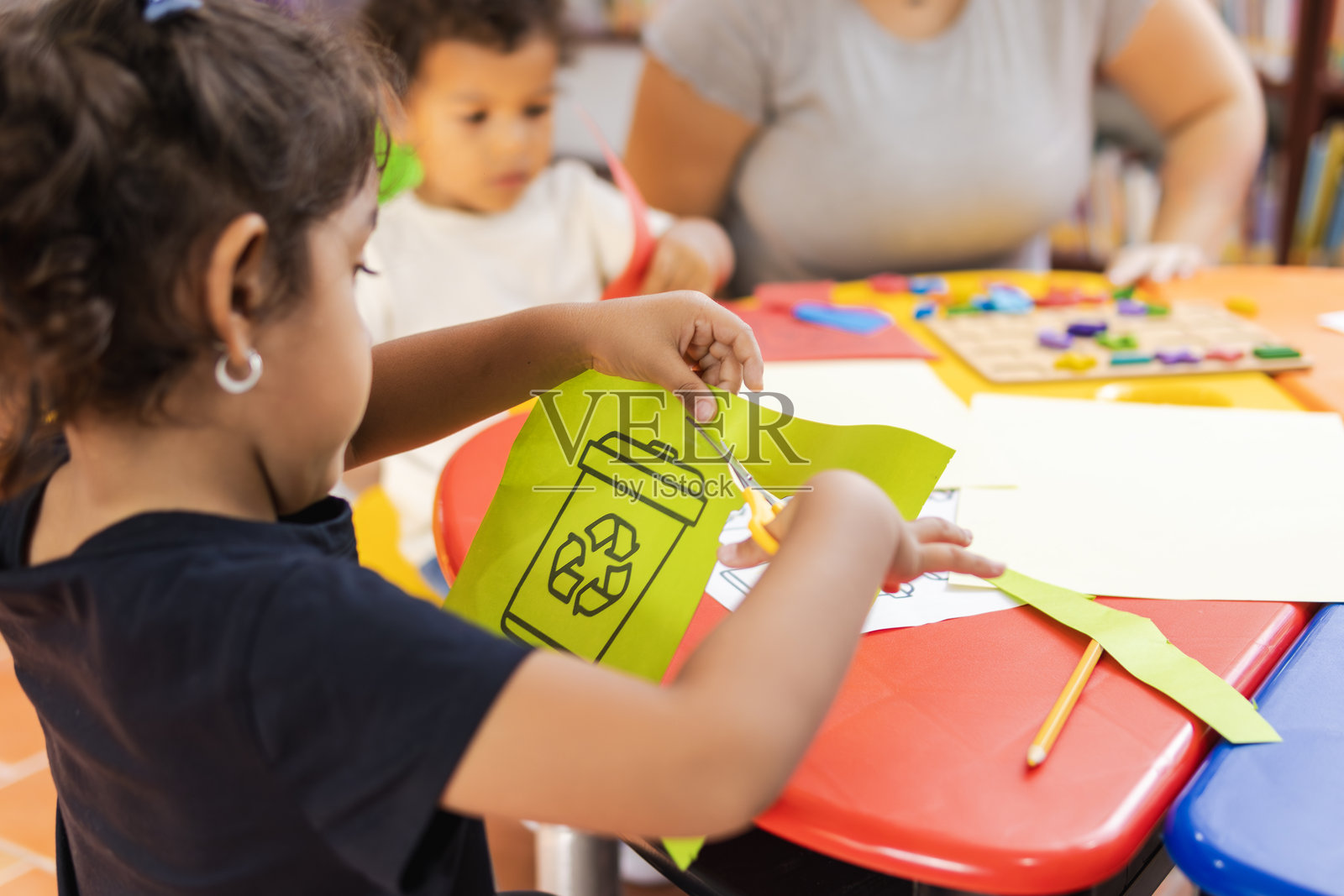 小女孩在幼儿园通过剪纸学习回收利用照片摄影图片