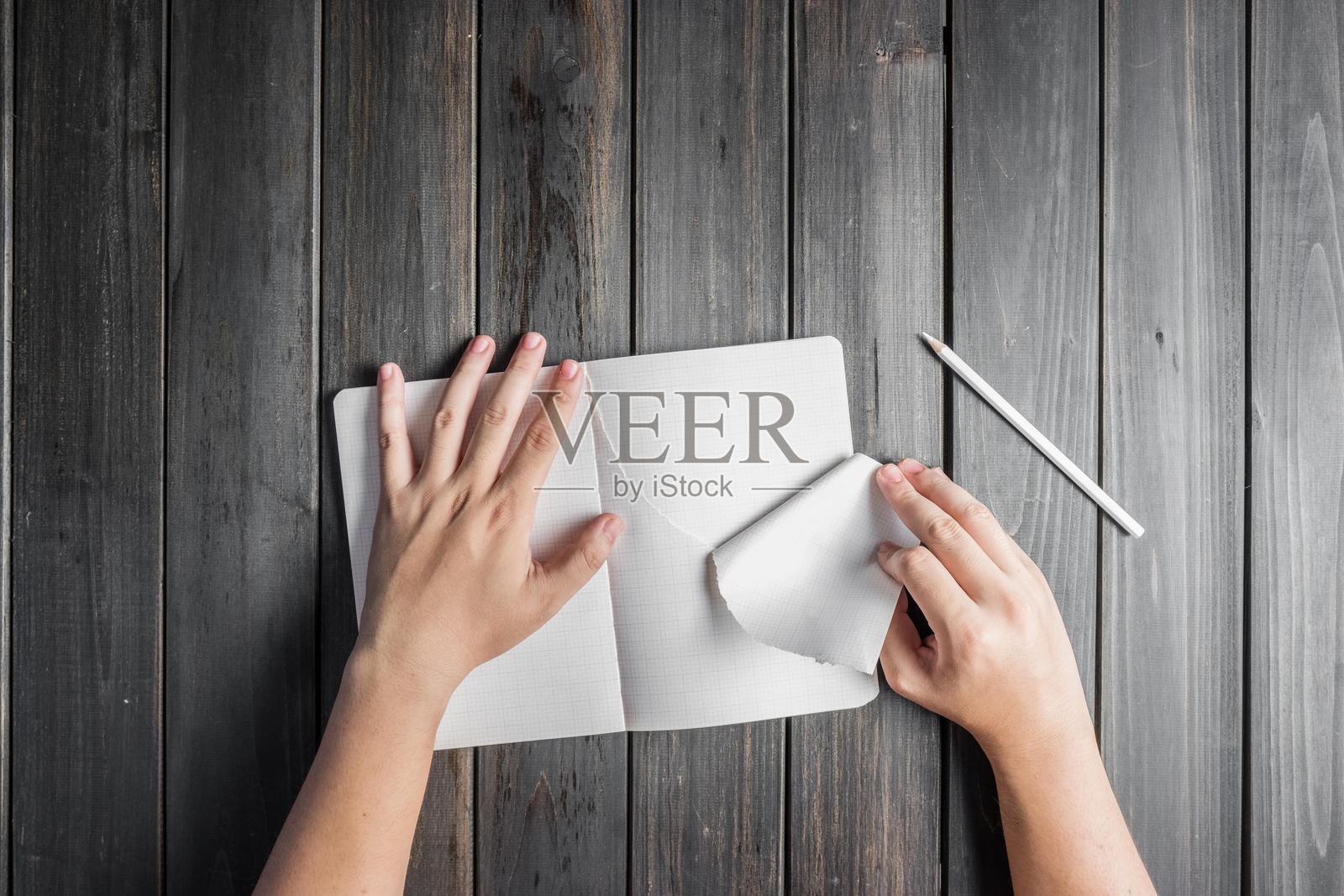 一个人从笔记本上撕下一页照片摄影图片