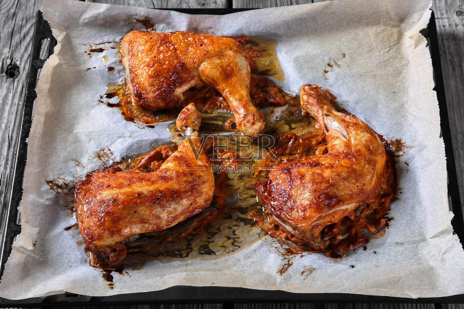 烤箱中烤制的三只鸡腿，俯视图照片摄影图片