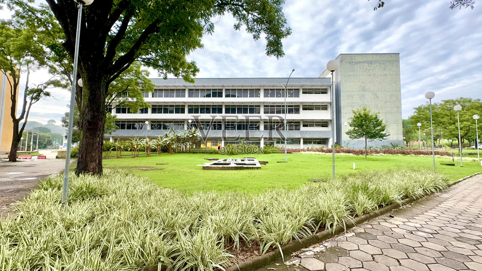 阳光明媚和多云的日子，白色和灰色的建筑以及一大片草地照片摄影图片