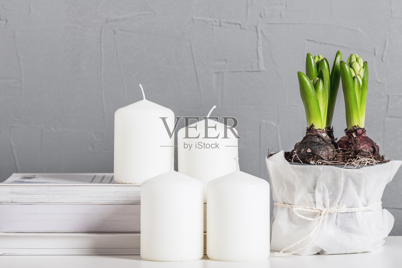 春季静物，花盆里盛开着风信子，蜡烛和书籍。斯堪的纳维亚室内风格。照片摄影图片