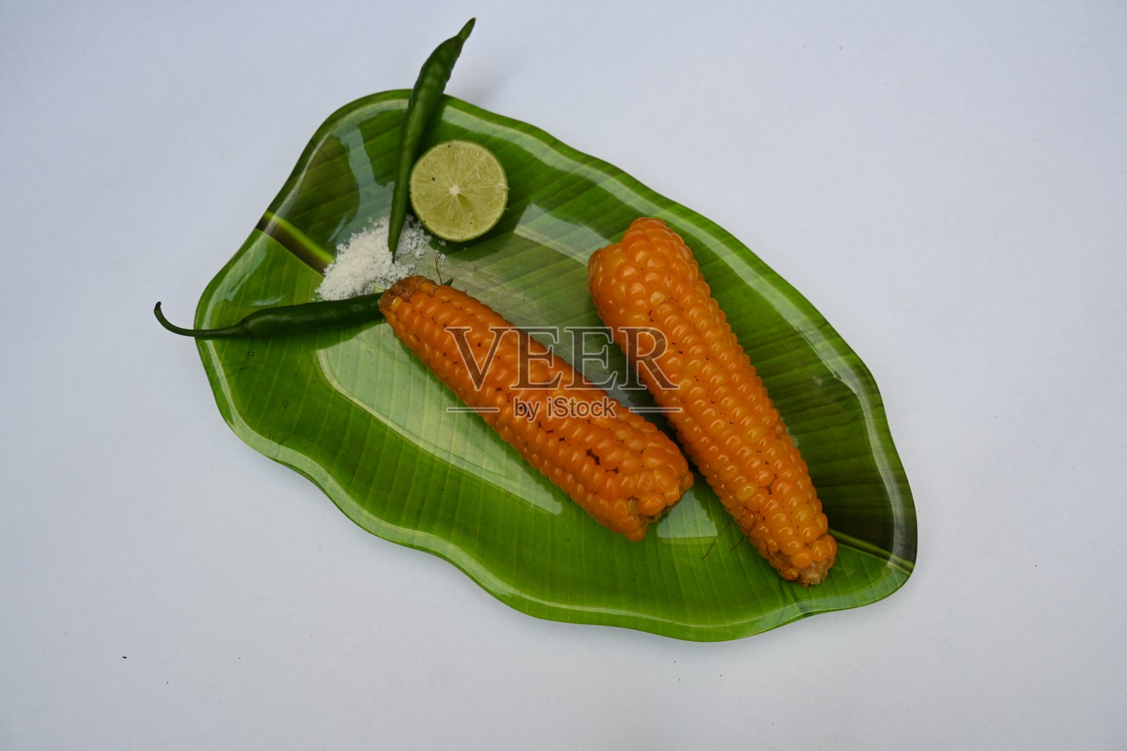 盘子上的煮甜玉米。照片摄影图片