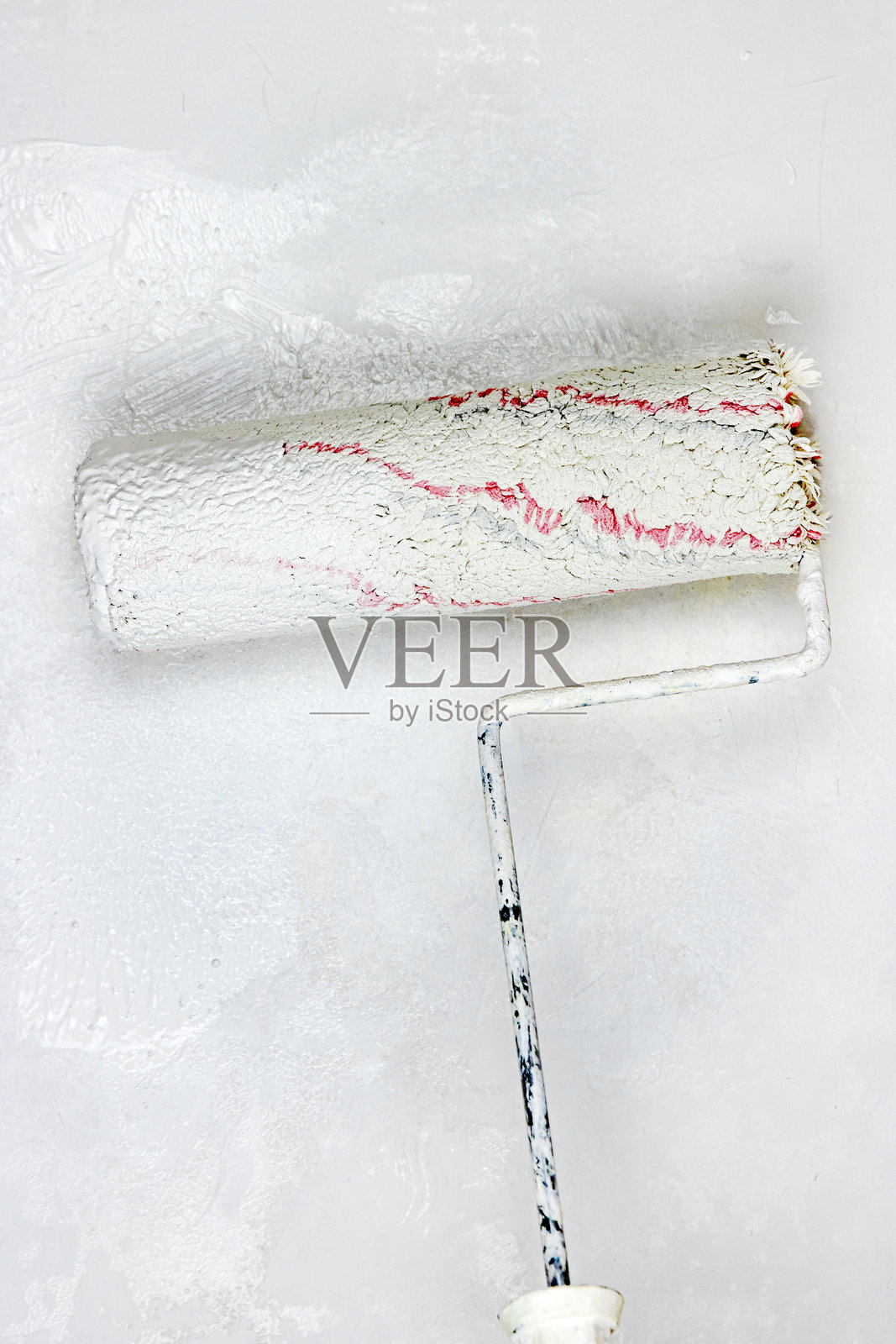 涂料滚筒特写，正在墙上涂抹新鲜的白色油漆。家庭装修和绘画的DIY过程，打造干净、现代的室内环境。家居改善和墙面改造。留白空间。照片摄影图片