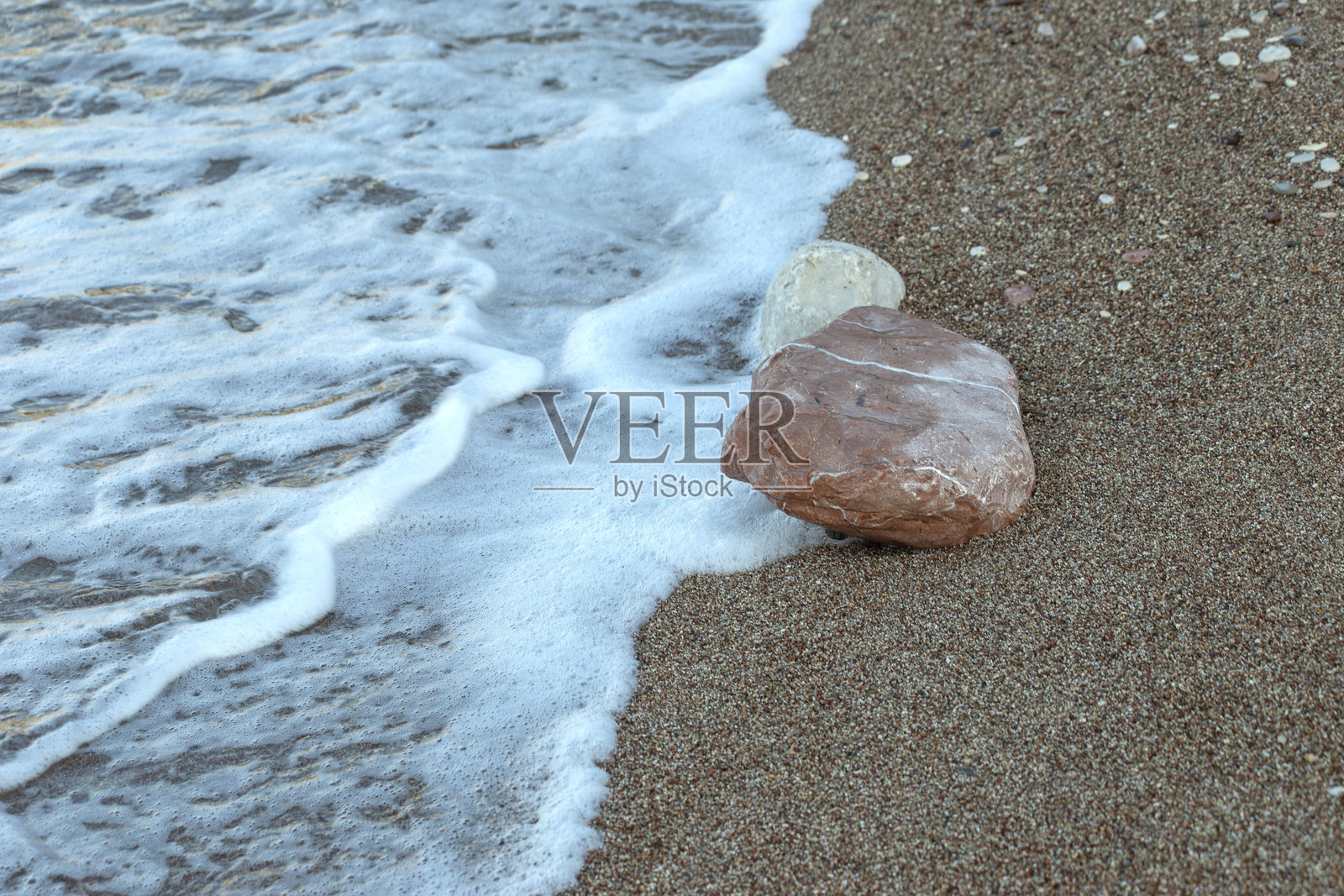 黑山布德瓦城市海滩上的多彩卵石与海泡沫。照片摄影图片