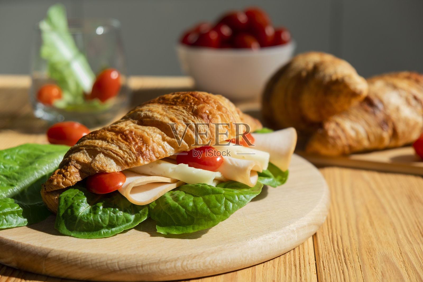 早餐氛围。木板上的火腿奶酪番茄沙拉可颂三明治。健康快餐。快速美味的早餐或午餐创意。早晨的餐点或小吃。照片摄影图片