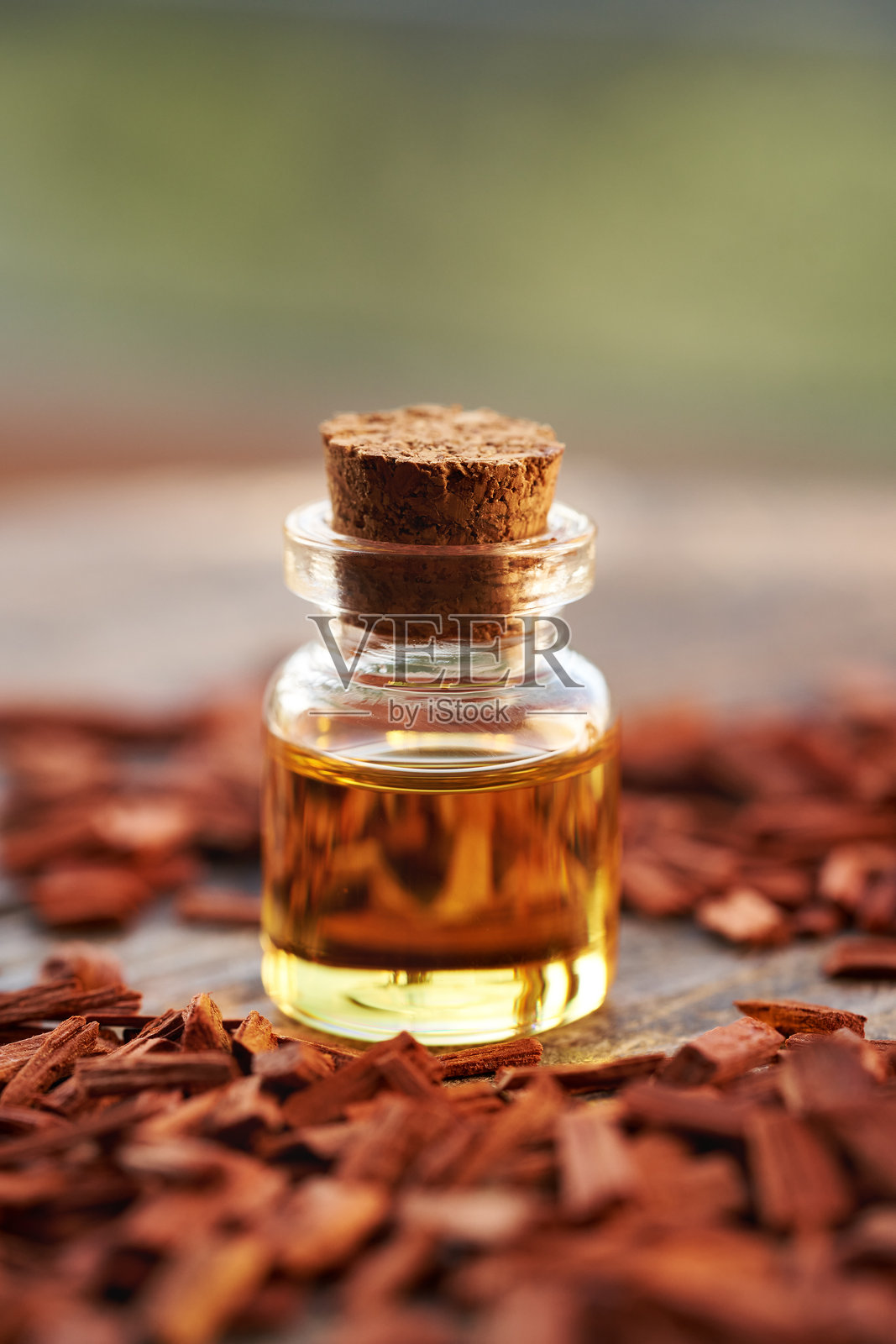 一瓶装有红檀木片的芳香疗法精油，留有空白空间照片摄影图片