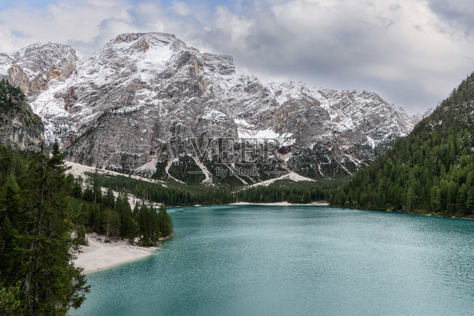 布拉耶斯湖，碧蓝的湖水被茂密的常青森林和陡峭的雪-covered悬崖环绕，云雾缭绕下形成了南蒂罗尔意大利令人叹为观止的阿尔卑斯美景。照片摄影图片