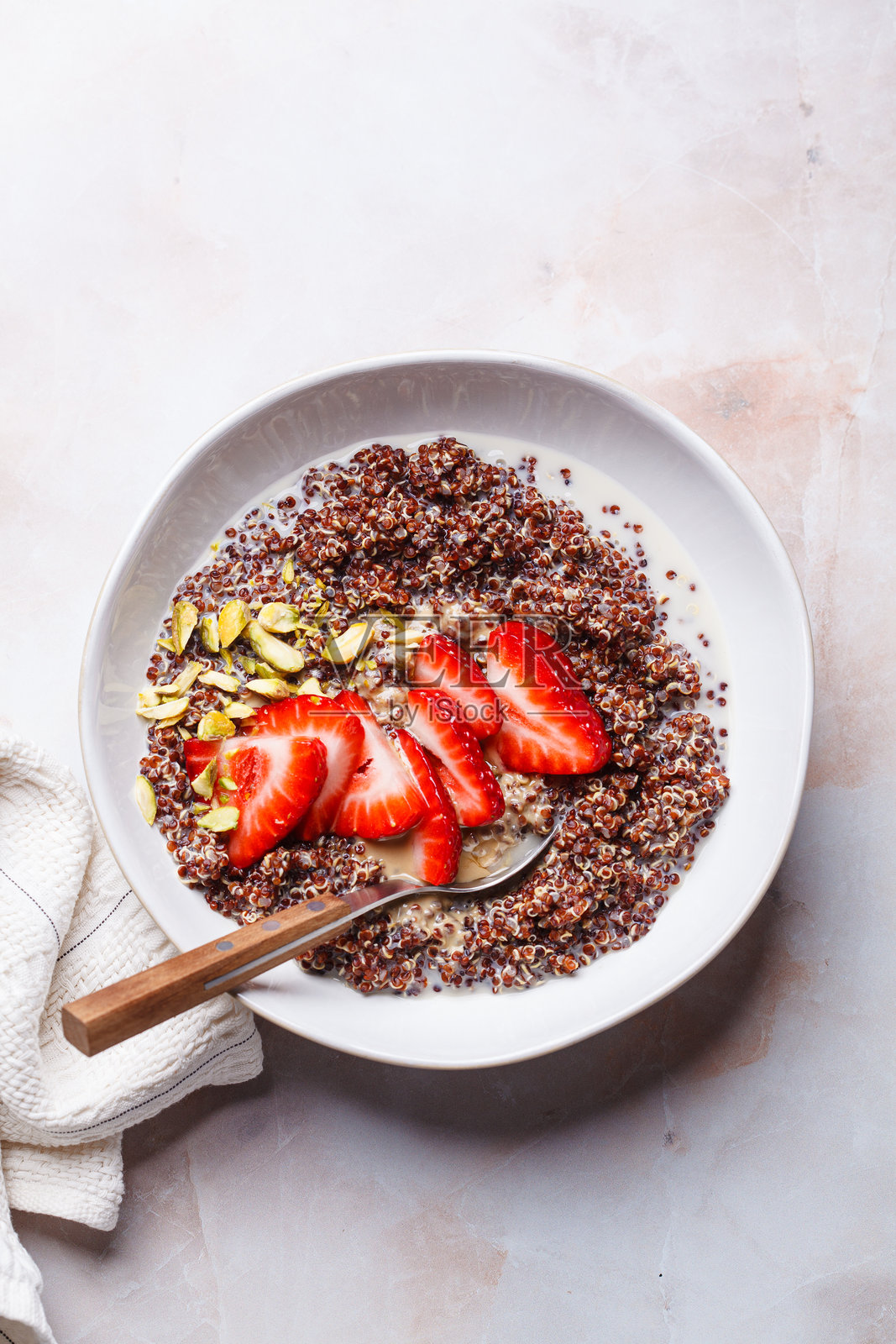 草莓和开心果的早餐藜麦碗。照片摄影图片