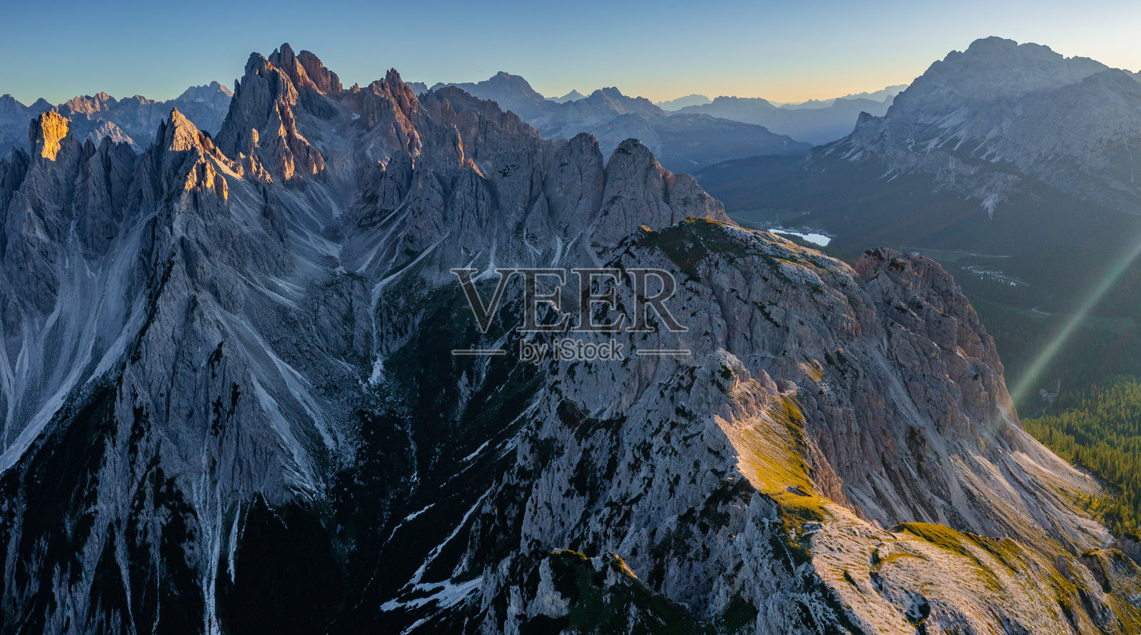 意大利阿尔卑斯山峰的鸟瞰图，夕阳照耀下被森林和山谷环绕。照片摄影图片