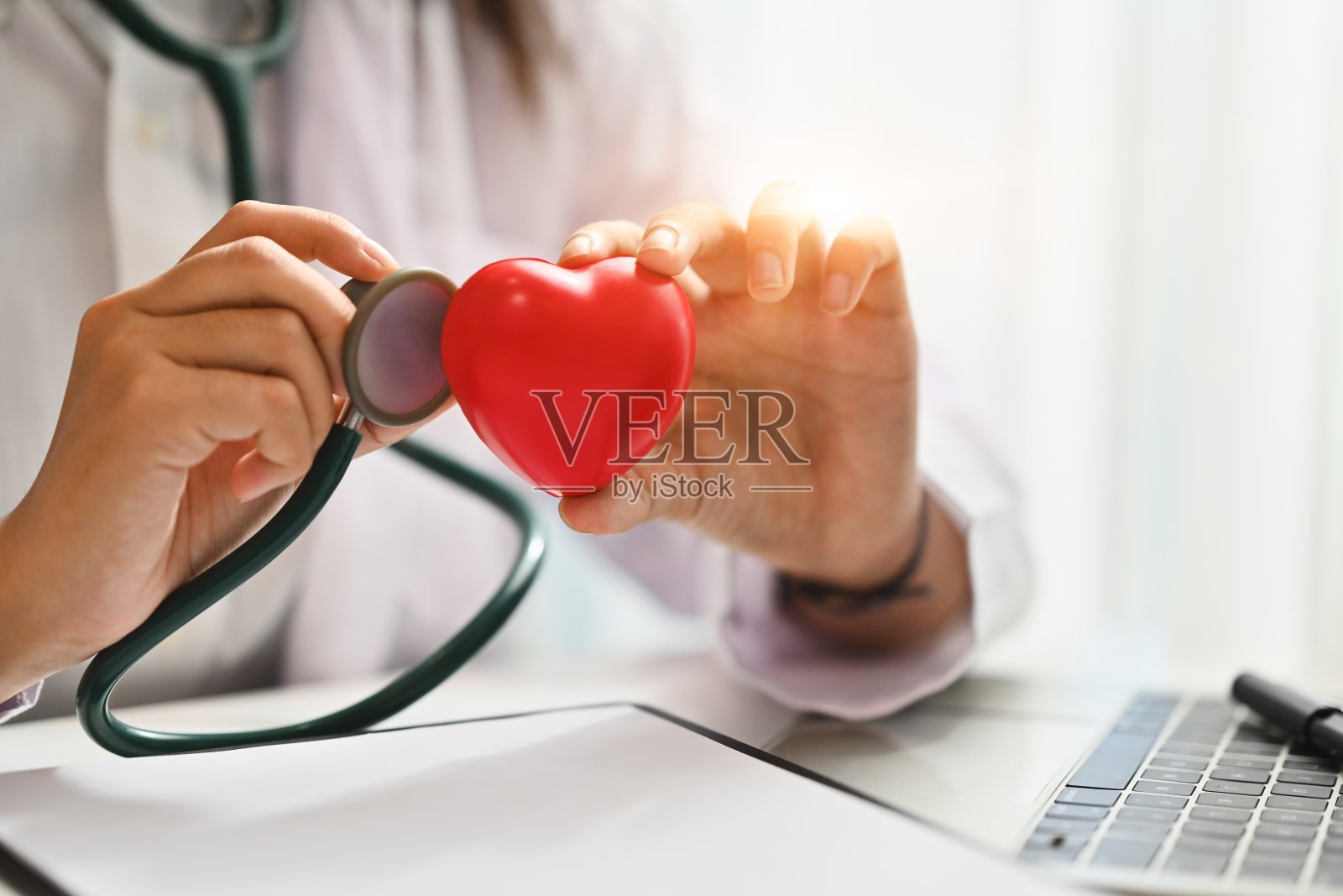医生拿着听诊器和红心。保健、心脏病、医疗和慈善理念照片摄影图片