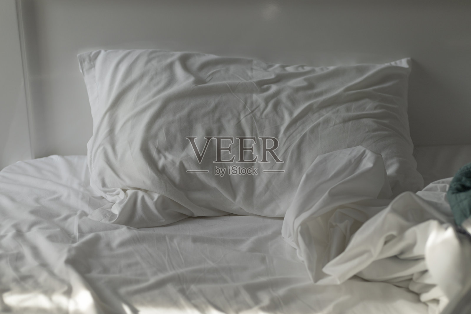 未整理的床，酒店房间内的白色床单照片摄影图片