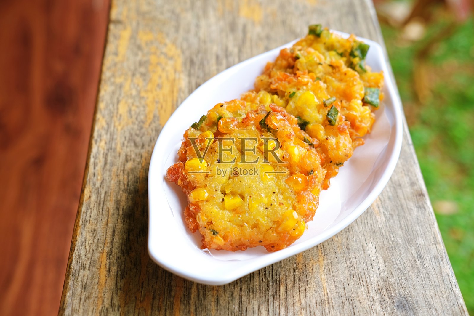 脆皮印尼玉米饼（Bakwan Jagung）盛在白色盘子里。照片摄影图片