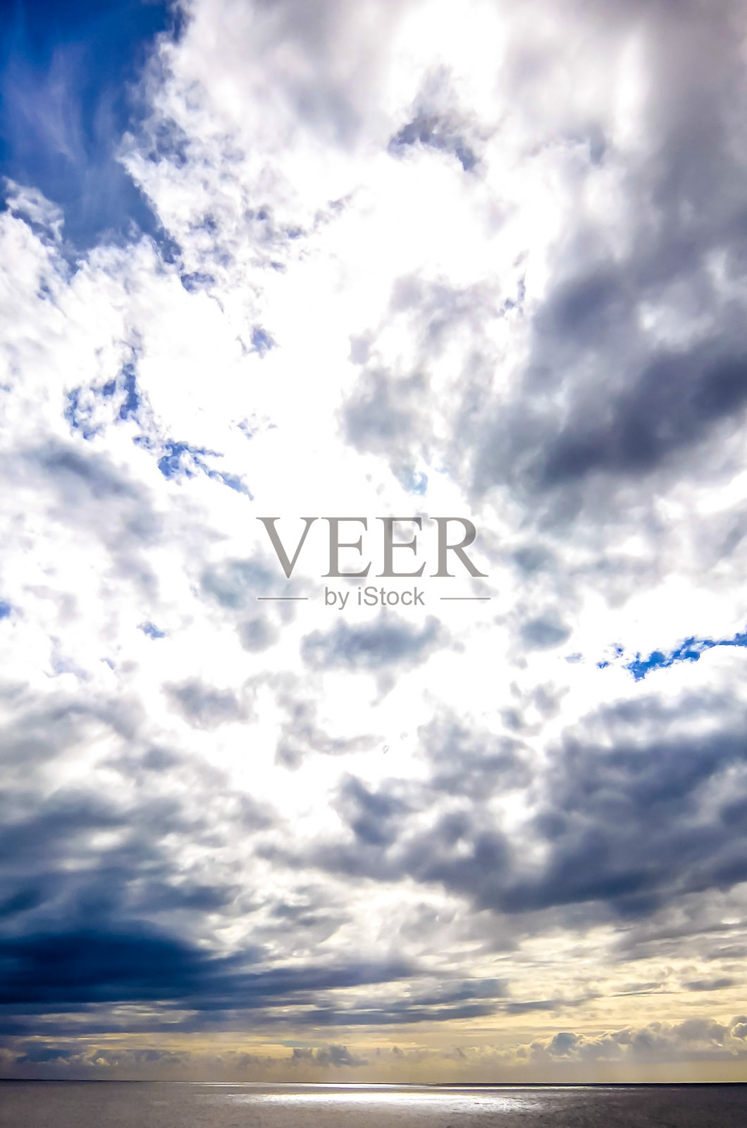 多云的天空中，明亮的太阳透过云层洒下光芒照片摄影图片