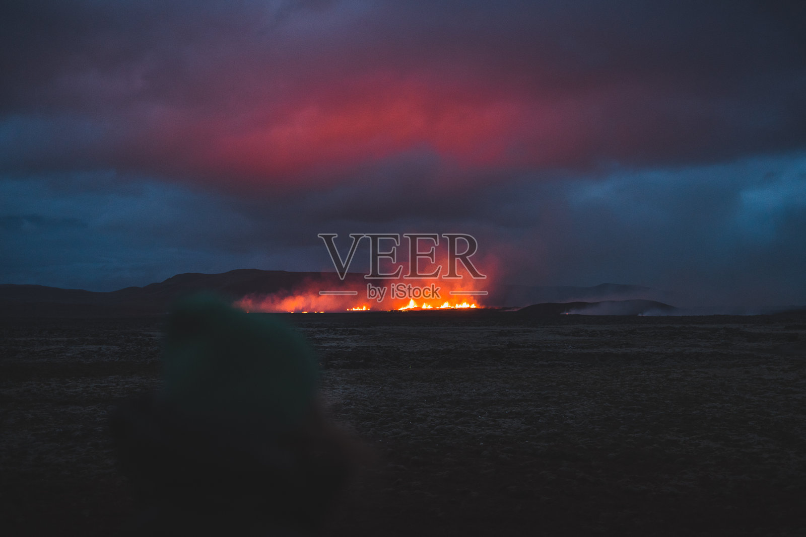 法格拉达尔斯山地区正在进行火山活动。冰岛格林达维克。明亮的火山喷发照亮了黑暗的冰岛夜空，发光的熔岩喷泉穿透了阴影。照片摄影图片