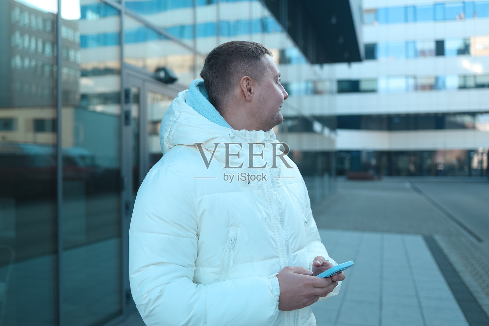 冬季城市街道上使用智能手机的人照片摄影图片