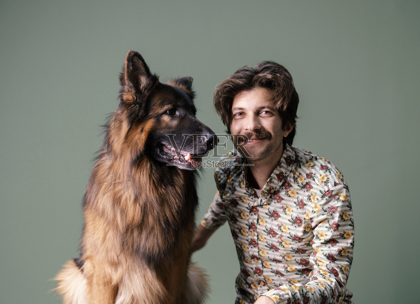 年轻男子与他的德国牧羊犬的工作室肖像照片摄影图片