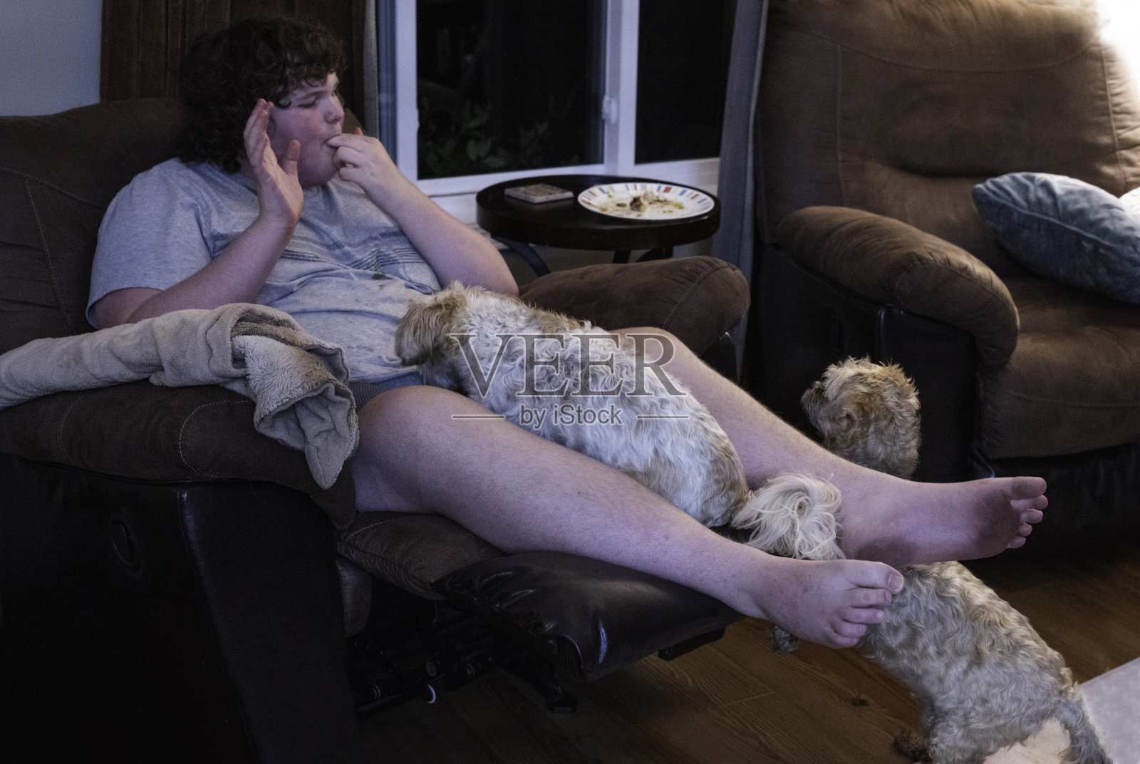 狗狗们在看男士吃鸡翅照片摄影图片