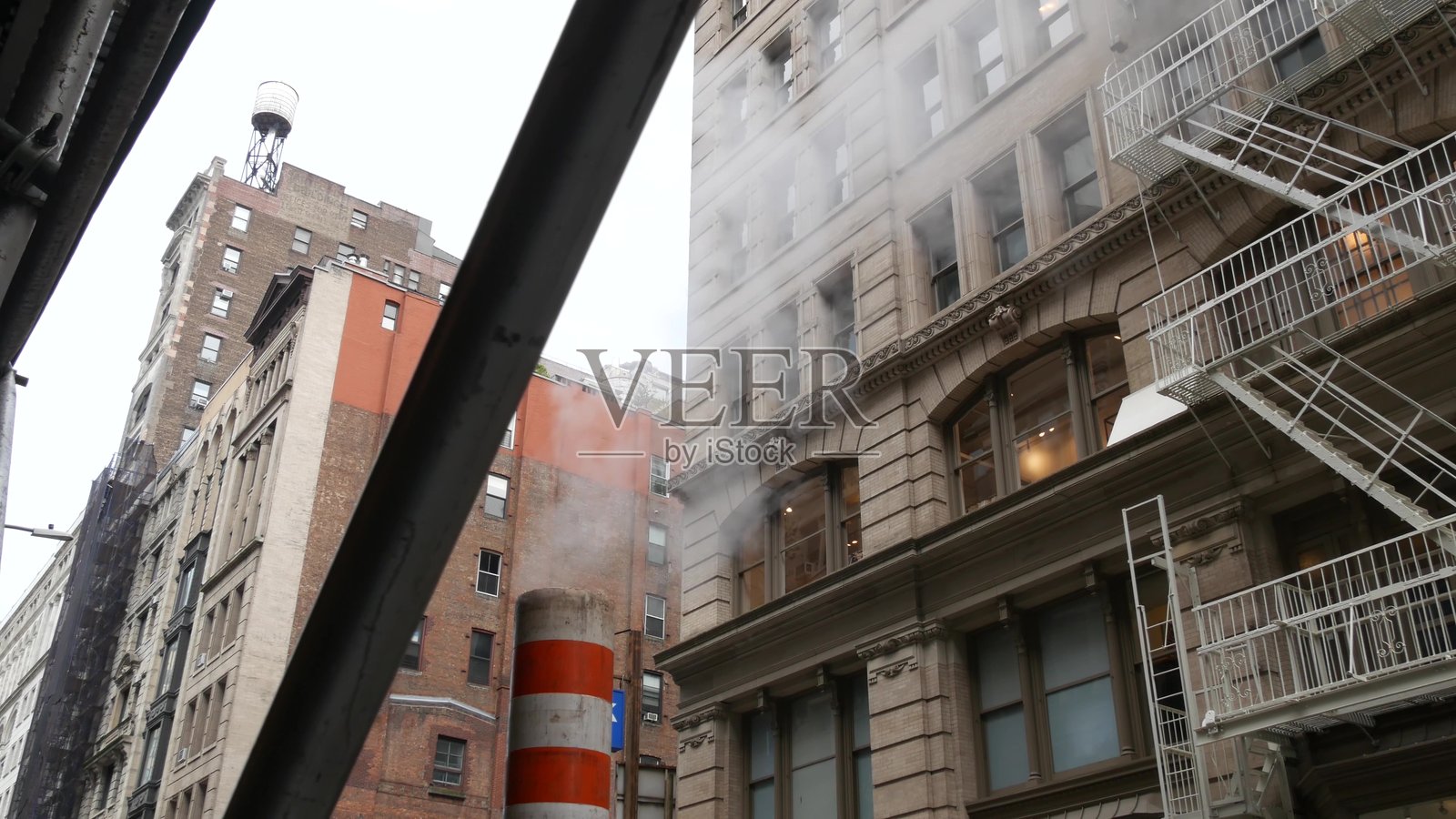 蒸汽排放,纽约市街道蒸汽系统,橙色蒸汽管道烟囱。管道冒出的热烟。照片摄影图片