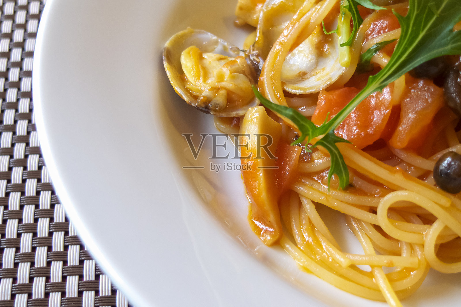 桌子上的番茄酱、蛤蜊和蔬菜意大利面照片摄影图片