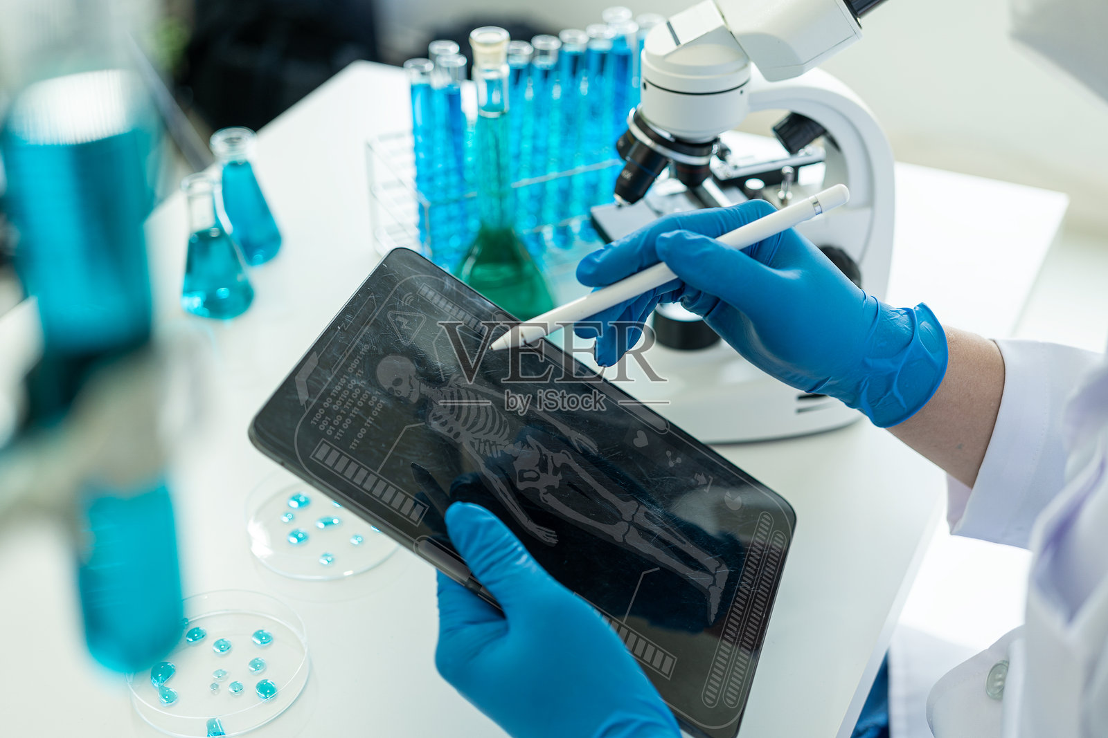 在生命科学实验室工作的医疗保健研究人员也要工作。显微镜和试管:科学家评估和分析研究数据。照片摄影图片