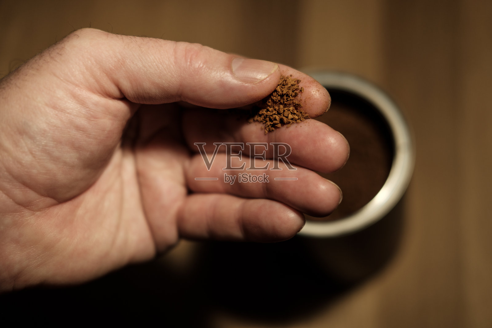 咖啡师手持冻干咖啡颗粒在滤器上方照片摄影图片