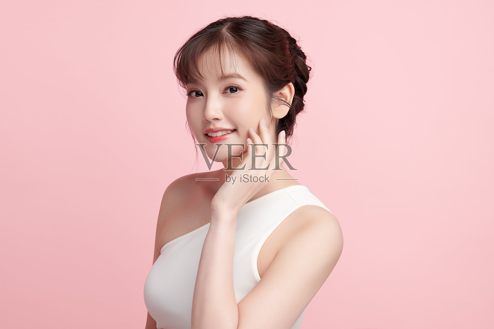 美丽的年轻亚洲女性，皮肤洁净清新，背景为粉色，面部护理，面部治疗，美容学，美容与水疗，亚洲女性肖像。照片摄影图片