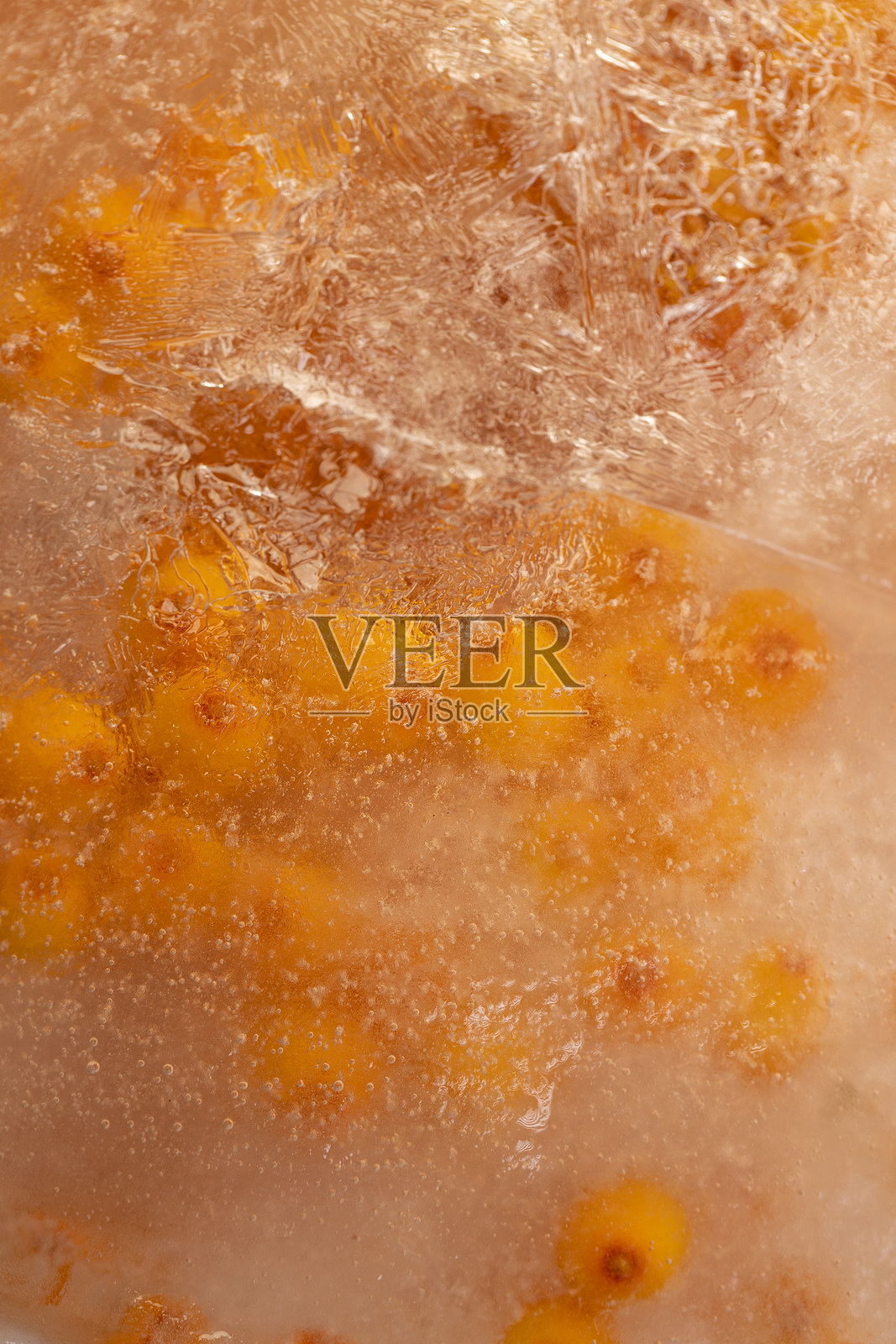 成熟的橙色沙棘浆果冻在水中照片摄影图片