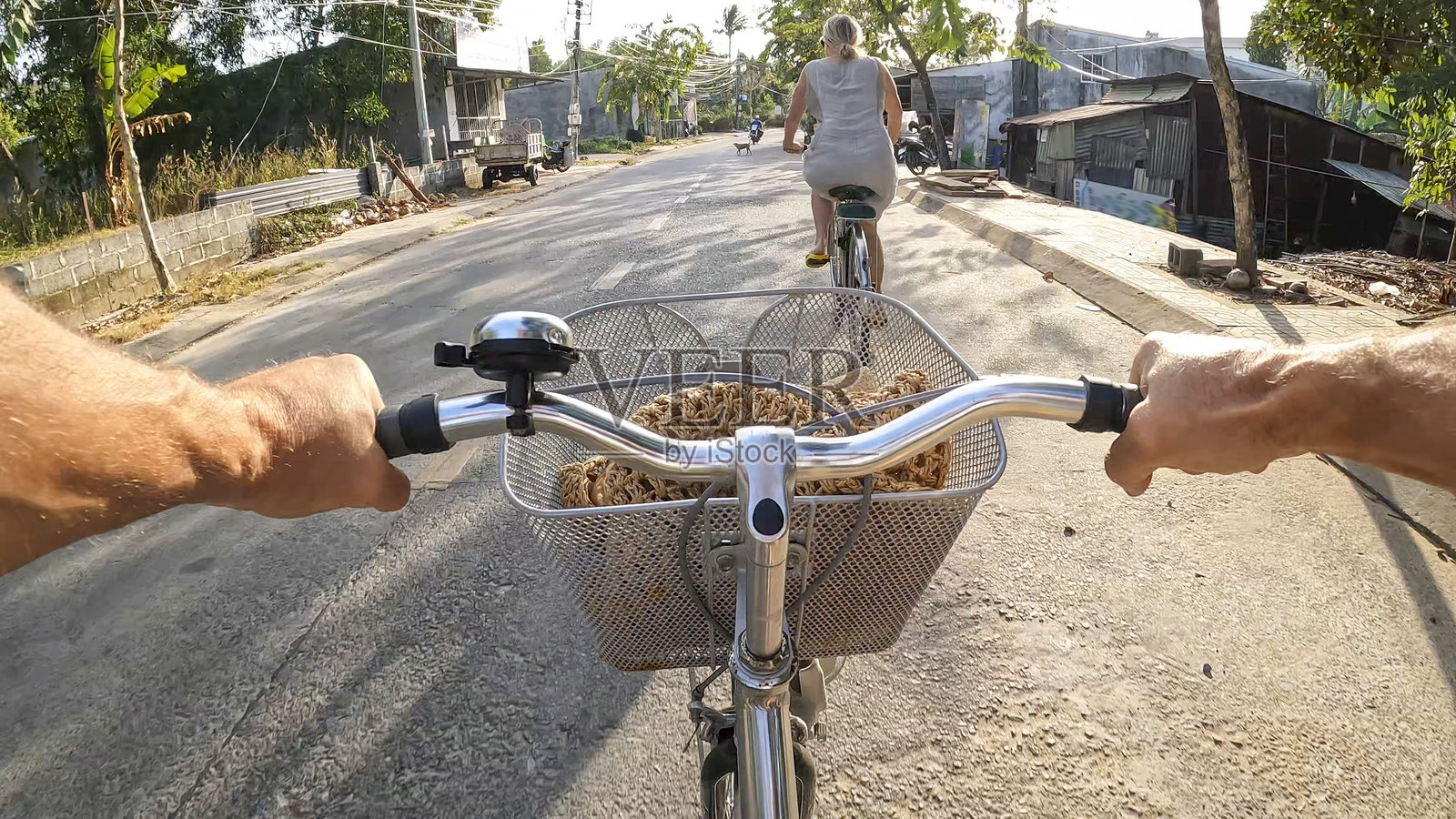 第一人称视角跟随村庄中的骑自行车者照片摄影图片