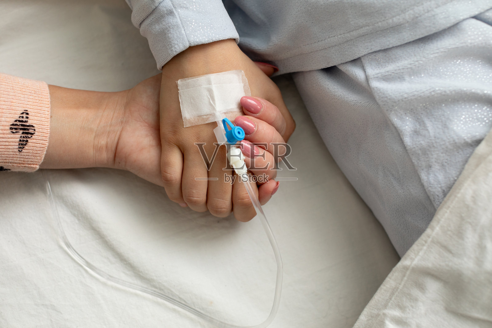 在医疗环境中温柔的时刻，手握在一起，象征着关怀与支持照片摄影图片