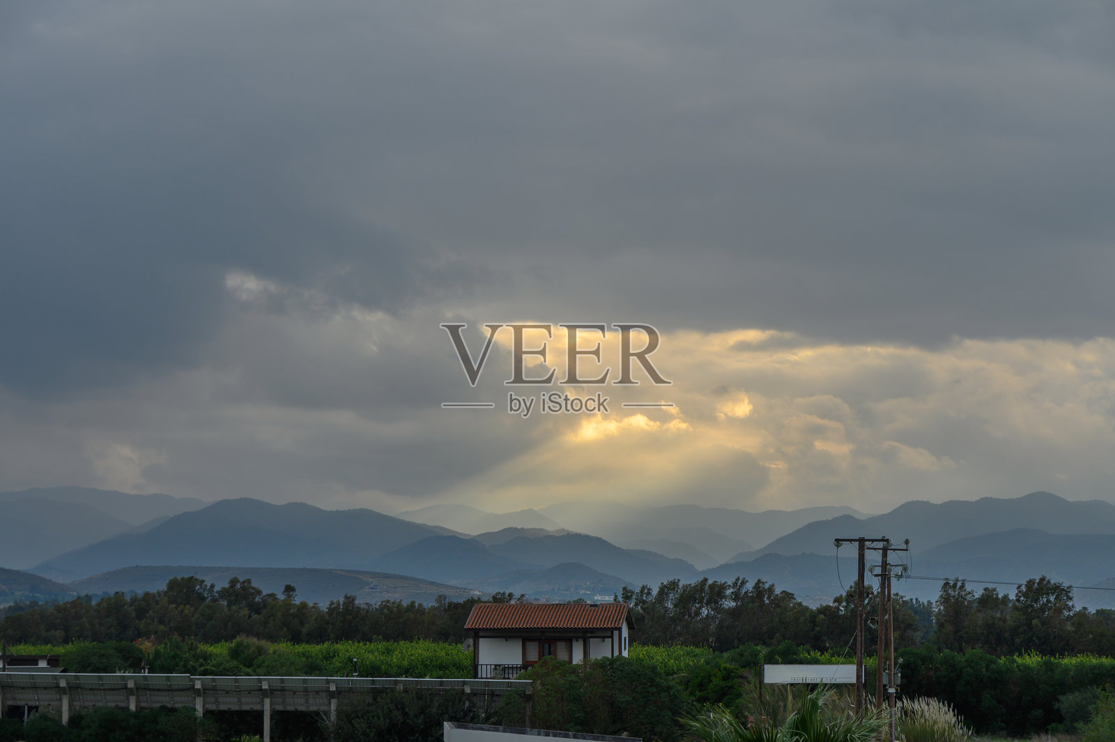 戏剧性的云层散开，露出黄昏时分宁静山脉景观上的金色光芒照片摄影图片