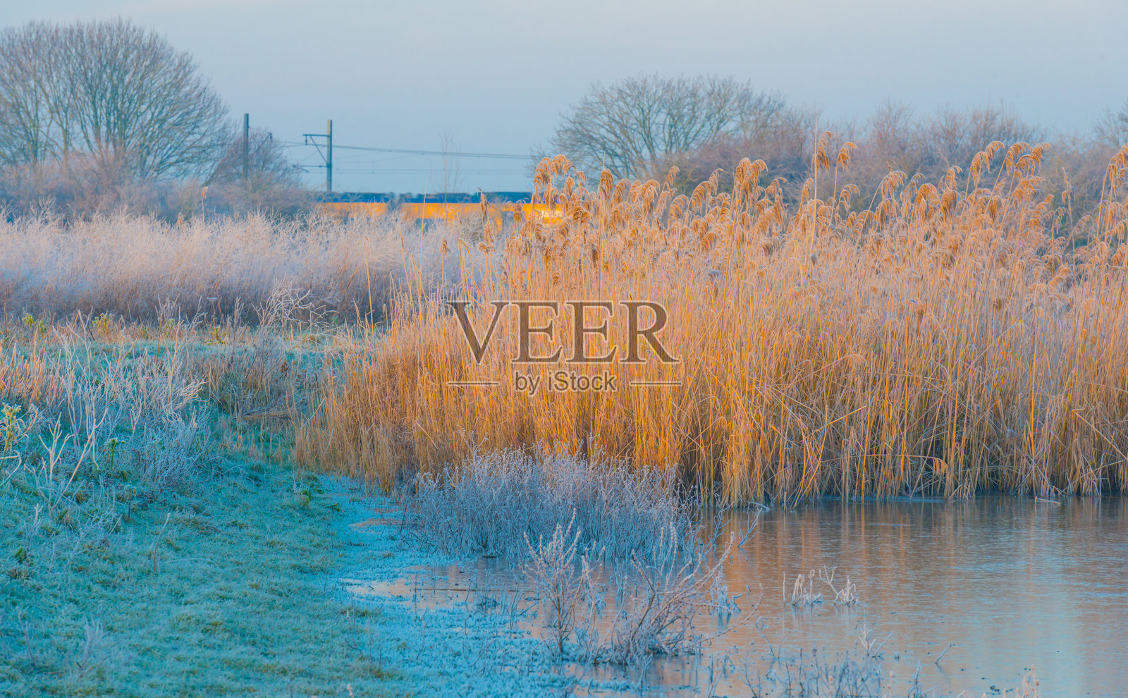 冬季日出时分，冰冻湖泊的边缘照片摄影图片